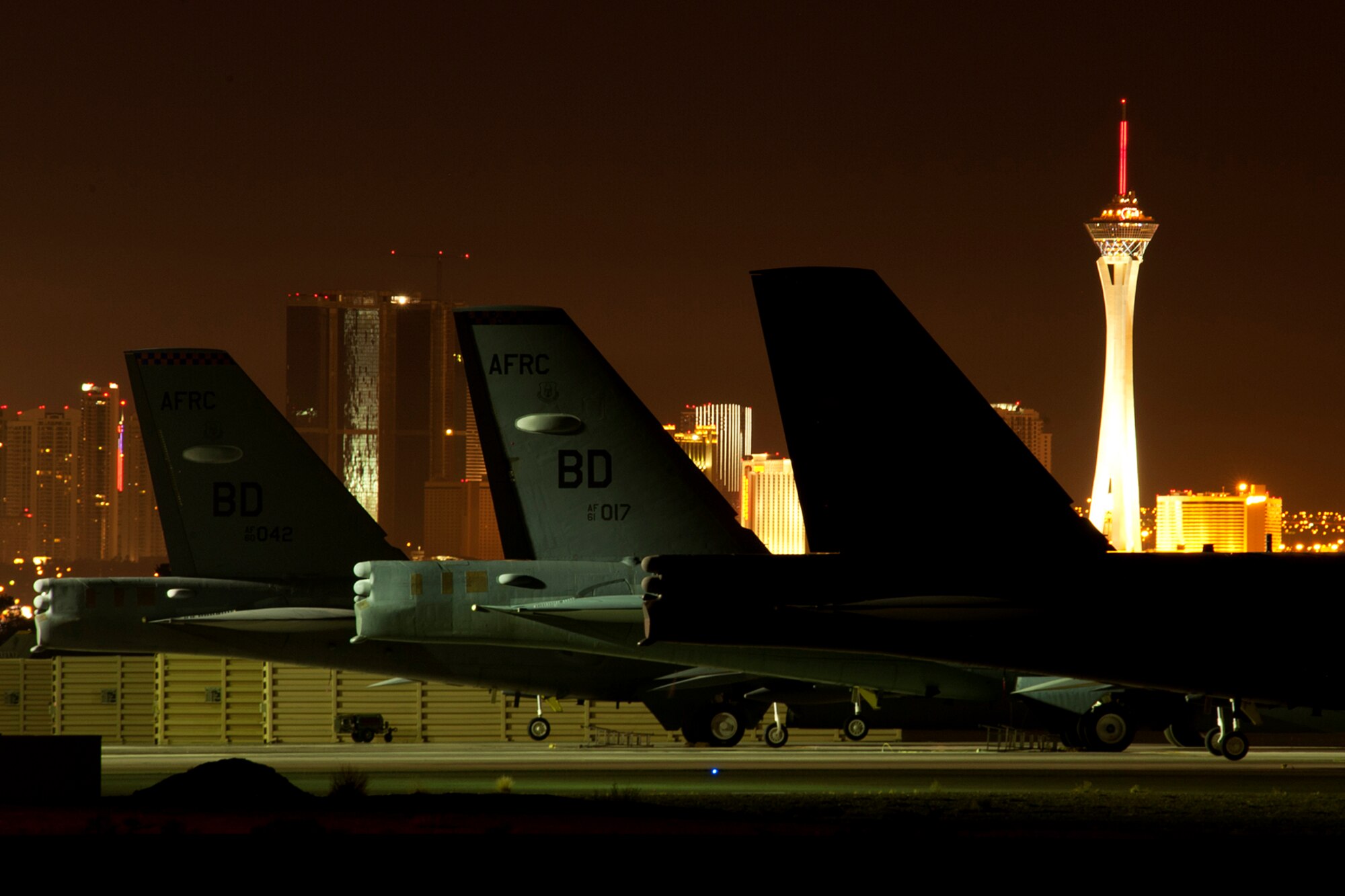 The Las Vegas skyline shines behind three B-52H Stratofortress bombers on the flight line at Nellis Air Force Base, Nev., June 11, 2012. The B-52s are assigned to the 93rd Bomb Squadron, 307th Bomb Wing, Barksdale AFB, La., and deployed to Nellis in support of a Mission Employment exercise. (U.S. Air Force photo by Master Sgt. Greg Steele/Released)