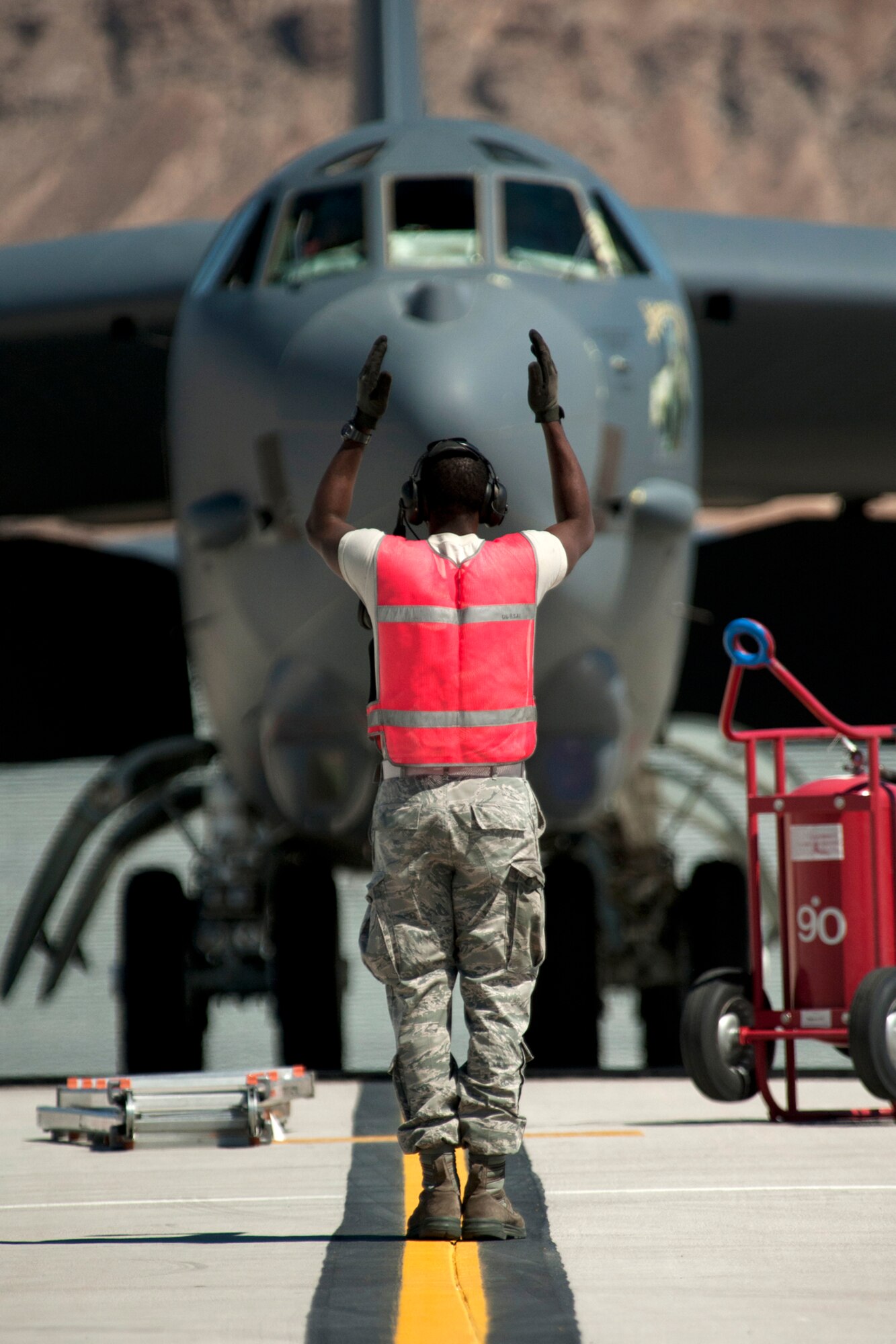 U.S. Air Force Airman 1st Class Stuart Mighty, 2nd Aircraft Maintenance Squadron crew chief, marshals a B-52H Stratofortress to a parking after its return from a sortie in support of a Mission Employment exercise, Nellis Air Force Base, Nev., June 10, 2012. A combined maintenance team of 45 personnel from the 307th and 2nd Bomb Wings from Barksdale AFB, La., deployed to Nellis in support of the exercise and generated 14 aircraft sorties, resulting in a 100 percent mission success rate. (U.S. Air Force photo by Master Sgt. Greg Steele/Released)