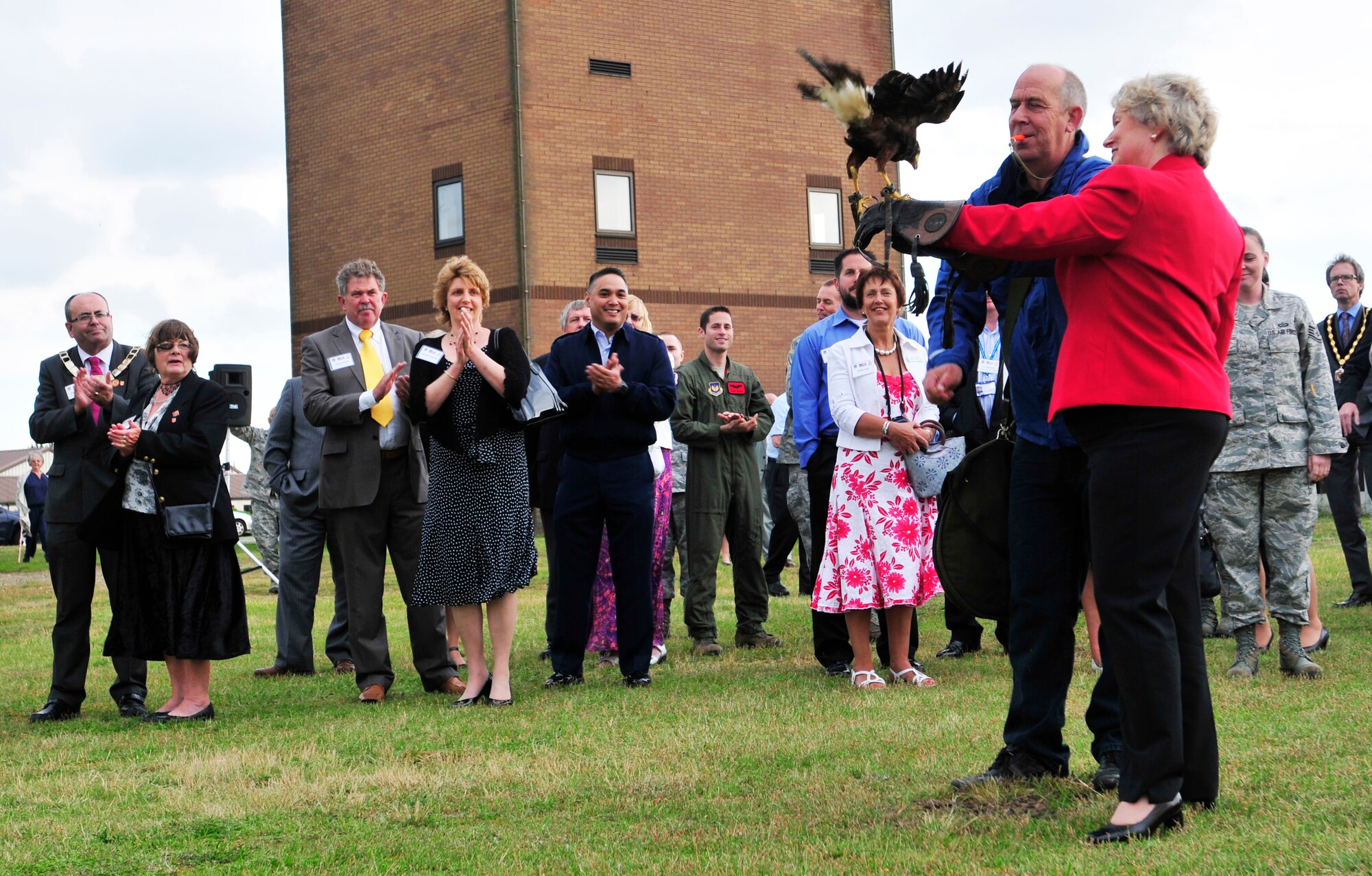 ROYAL AIR FORCE LAKENHEATH, England - Keith Mutton, Phoenix Bird Control falconer, whistles for his bird to land on the hand of Councillor Sue Thomson, South Norfolk District Council, during a birds of prey demonstration at the summer reception by the air traffic control tower, June 22, 2012. The visitors, including three new honorary commanders, witnessed an explosive ordnance disposal demonstration and toured the air traffic control tower among other activities during the reception. (U.S. Air Force photo by Senior Airman Tiffany M. Deuel)
