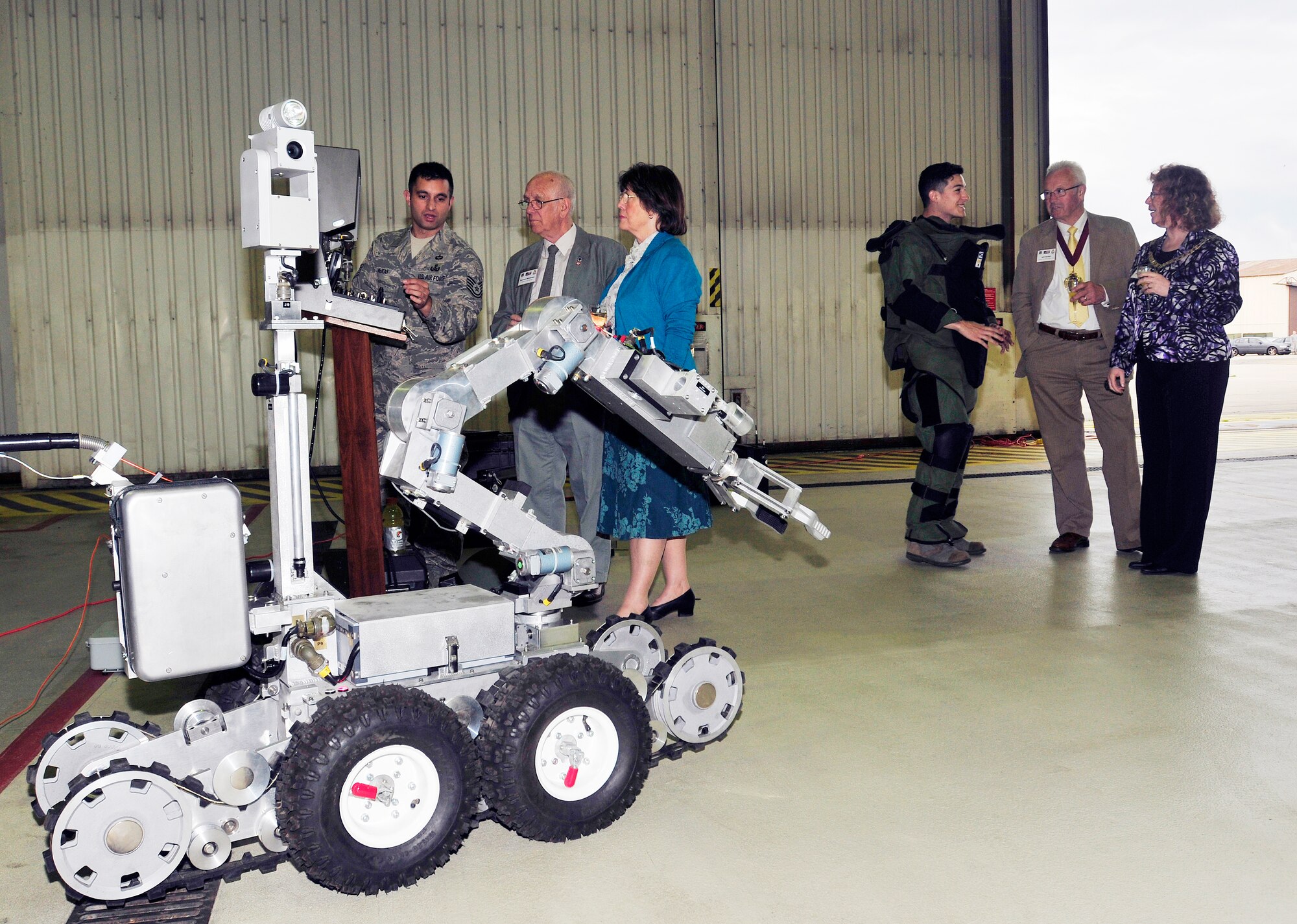 ROYAL AIR FORCE LAKENHEATH, England - (left to right) Tech. Sgt. Chris McKay, 48th Civil Engineer Squadron explosive ordnance disposal team leader, explains the functions of the F6 robot to Smiley Mildwater, Mildenhall Chairman of Aircrew Association, and wife Cherry while Senior Airman Kenneth Park, 48th CES EOD team member, speaks with Will Burton, Mayor of Ely, and wife Siobhan, at the summer reception in Hangar 7, June 22, 2012. The visitors, including three new honorary commanders, witnessed a birds of prey demonstration and toured the air traffic control tower among other activities during the reception. (U.S. Air Force photo by Senior Airman Tiffany M. Deuel)