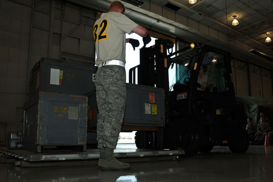 Master Sgt. Robert Steckmeyer, 32nd Aerial Port Squadron air transportation specialist, spots a forklift operated by Senior Airman Michael Smith, 32 APS air transportation specialist, as part of the cargo pallet build-up event during the Port Dawg Challenge at Dobbins Air Reserve Base, Ga., June 21, 2012. This event is designed to evaluate teams on the correct usage of restraints, weight limits on pallets to be shipped and accurate usage of spotters when using forklifts to load cargo pallets for transportation. (U.S. Air Force photo by Senior Airman Joshua J. Seybert/Released)
