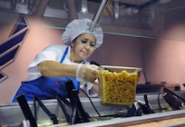 Diana Bailey,  salad bar attendant, places croutons on the salad bar, along with other healthy fresh vegetables and greens in preparation for the lunch hour at the Joint Base San Antonio-Randolph Rendezvous Dining Facility June 21.  ( U S Air Force Photo by Don Lindsey)
