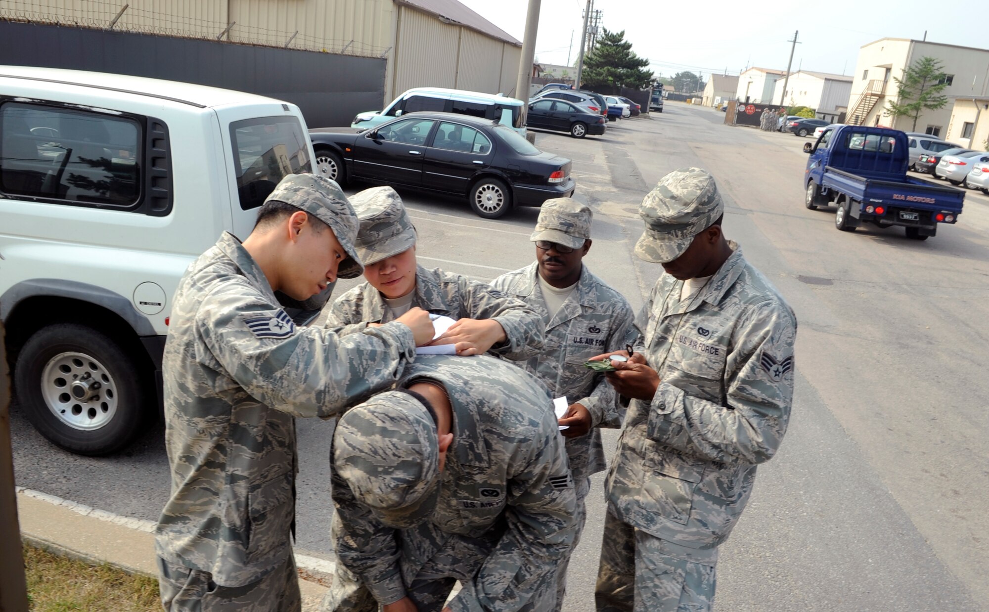 Airmen from the 8th Civil Engineer Squadron plot coordinates on a map June 21, 2012, at Kunsan Air Base, Republic of Korea. The land navigation training taught them how to pace count, read coordinates, and use a map and compass to find their destination. (U.S. Air Force photo/Senior Airman Brigitte N. Brantley)