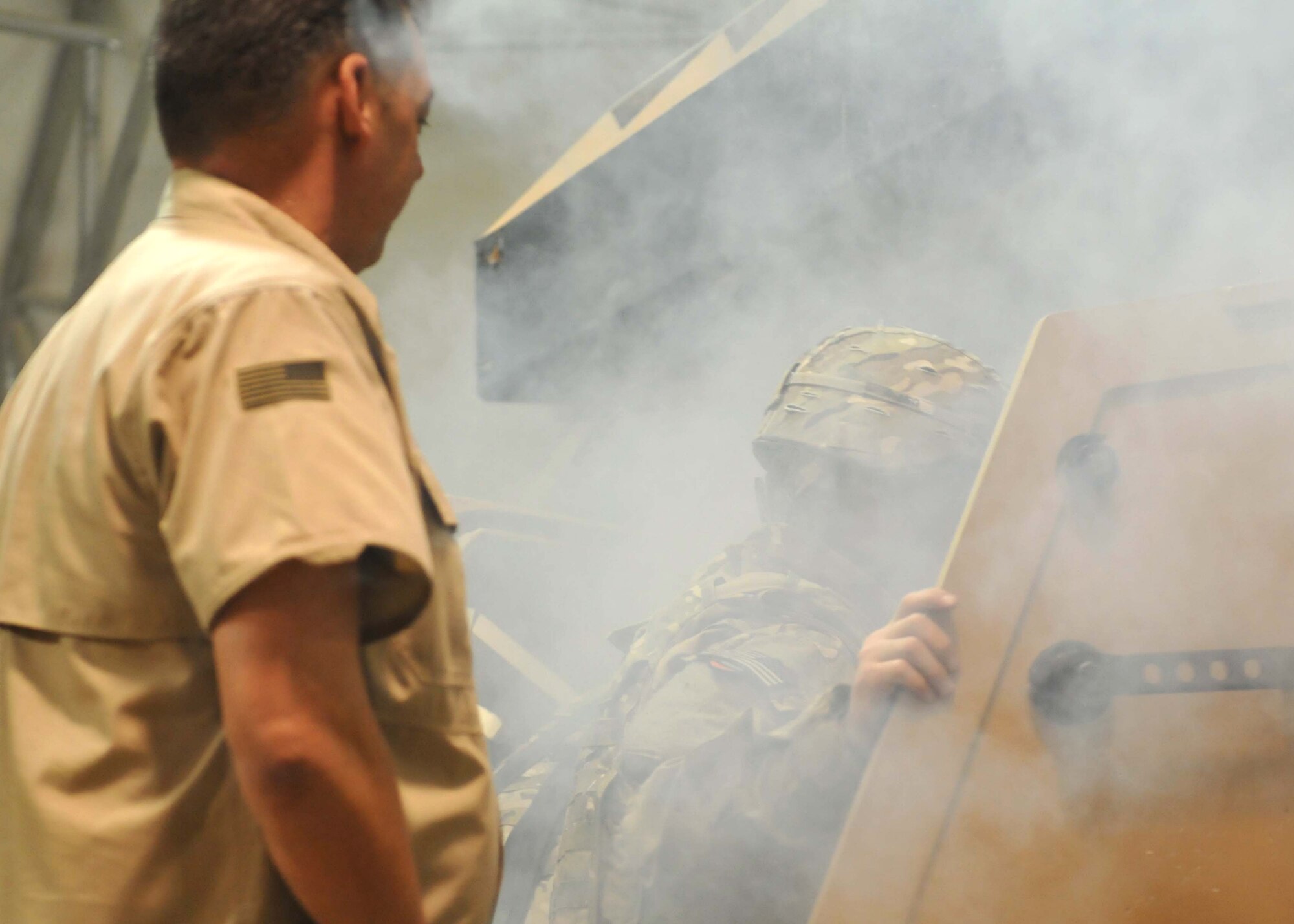 Patrick Franko, the senior instructor for the Mine Resistant Armored Protected egress training at Kandahar Airfield, watches closely as Soldiers from 2nd Brigade, 2nd Infantry Division, escape from an upside-down trainer, June 10. Franko ensures everyone inside the trainer uses proper techniques to clear the vehicle. (U.S. Army National Guard photo/Spc. Tyler Meister)