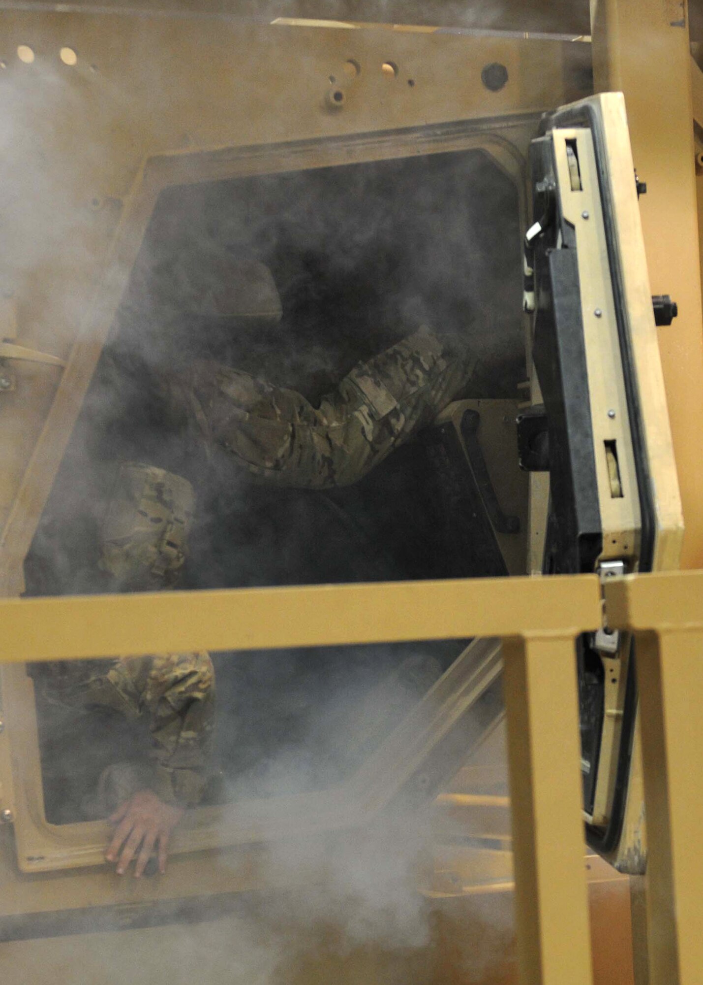 Soldiers from 2nd Brigade, 2nd Infantry Division, work quickly to remove themselves from an upside-down vehicle during Mine Resistant Armored Protected egress training on Kandahar Airfield, June 10. Students in the class experience the difficulties of realistic egress, including smoke effects and empty water bottles hampering their escape. (U.S. Army National Guard photo/Spc. Tyler Meister)