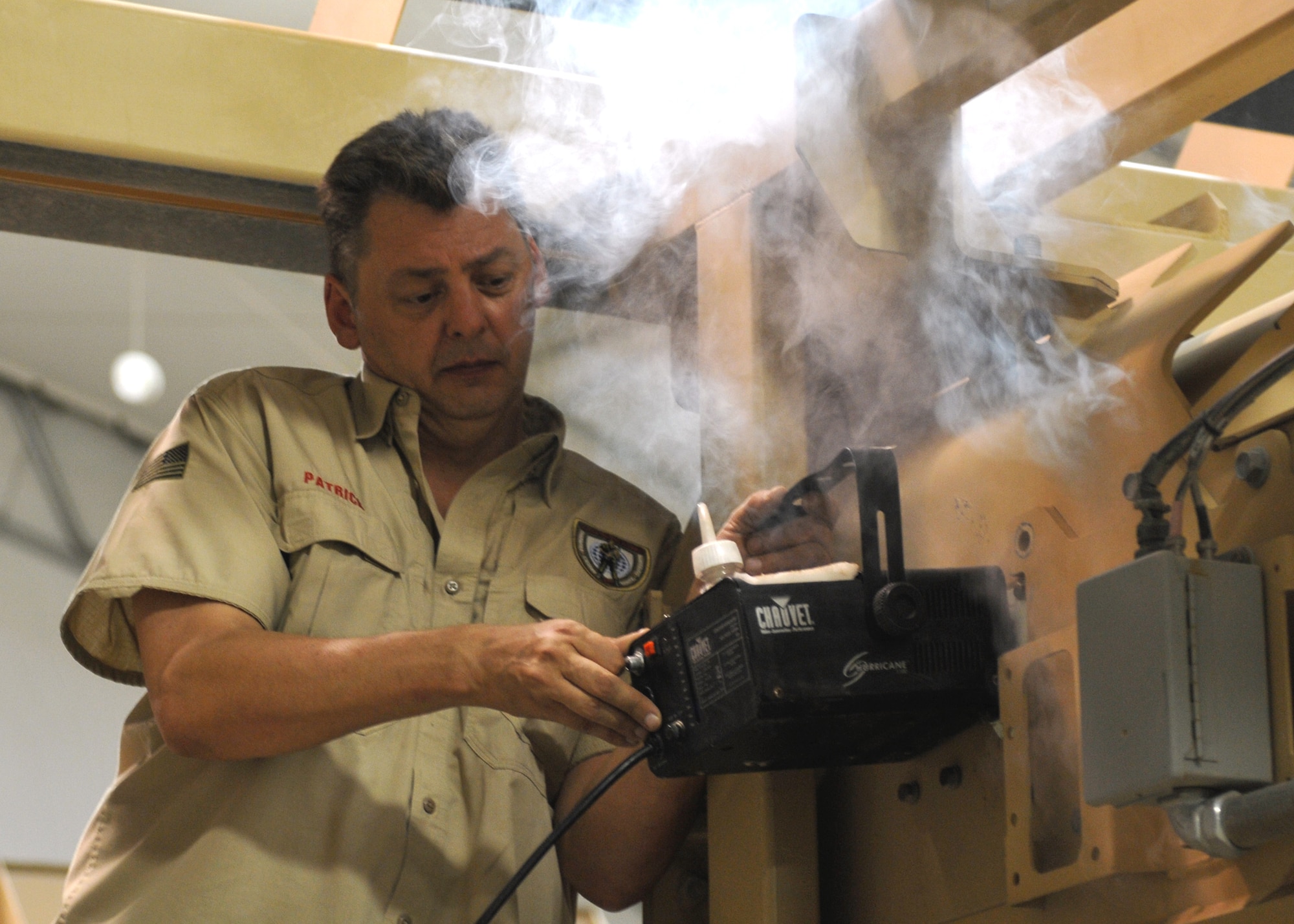 Patrick Franko, the senior Mine Resistant Armored Protected egress trainer at Kandahar Airfield, uses a smoke machine to help simulate realistic rollover conditions during a training session June 11. All U.S. service members are required to conduct rollover training upon entry into a combat theatre.(U.S. Army National Guard photo/Spc. Tyler Meister)