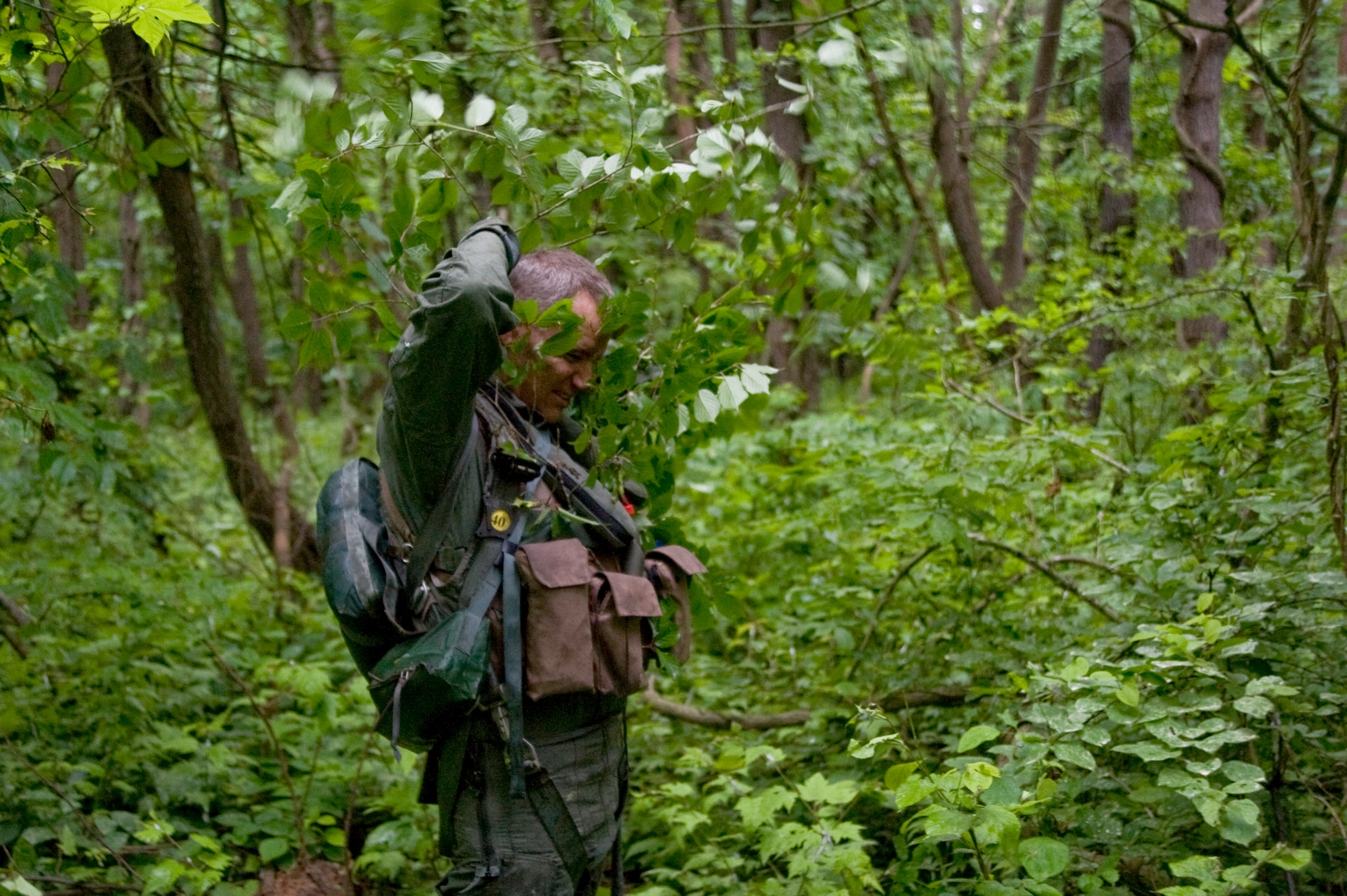 U.S. Air Force Chief Master Sgt. James Laurent, 35th Fighter Wing command chief, uses branches to blend in with the surrounding vegitation during Survival, Evasion, Resistance and Escape training at Draughon Range, Japan, June 20, 2012. Blending in with the surroundings increases personnel’s chances of evading capture while isolated. (U.S. Air Force photo by Staff Sgt. Nathan Lipscomb/Released)
