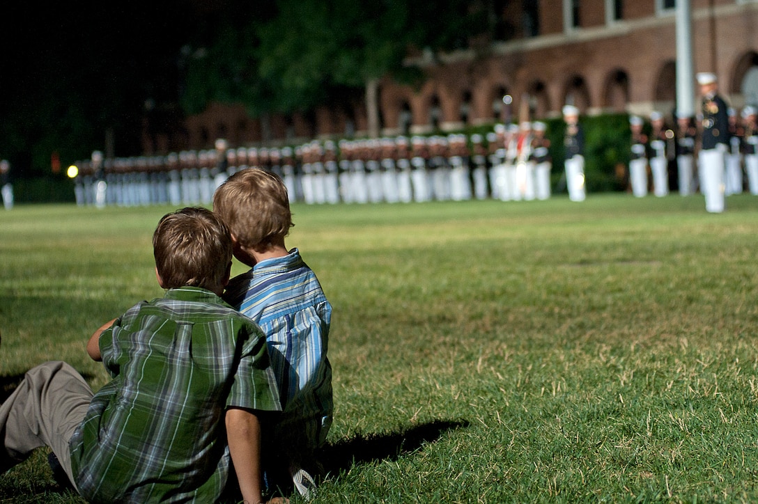 Derek Krueger, green shirt, and his brother Austin Krueger, blue shirt, watch a Friday Evening Parade at Marine Barracks Washington June 22.