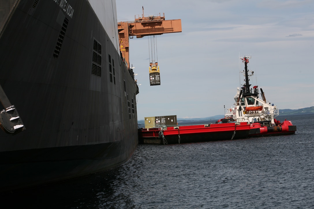 The USNS Sgt Mate Kocak, using a cargo crane, off loads shipping containers onto a waiting barge during an off-load/cross-leveling operation to retrograde equipment into the caves, belonging to the Marine Corps Prepositioning Program-Norway.  During this operation more than 150 vehicles and 200 shipping containers were transferred on or off the Kocak and staged for transportation to the caves or loaded back onto the ship. The MCPP-N facility is comprised of eight locations totaling more than 900,000 square feet of storage space. Inside the caves is  471,445 sq. ft. of climate controlled storage space, regulated to between 45 to 55 percent humidity and a regulated temperature of between 45 to 50 degrees. This precise regulation allow for tents, vehicle tires and parts and other climate sensitive equipment to be stored safely, and maintain a high level of accessibility to be readily deployable for any contingency that may arise.