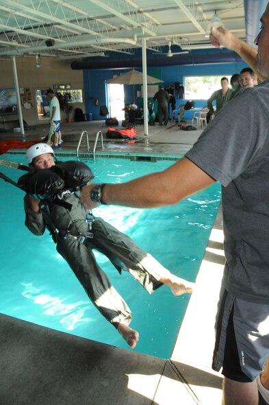 Maj. Ricardo “Stinky” Colon an F16 pilot with the 180th Fighter Wing is pulled into a pool for water survival training at the Aqua Hut, Toledo, Ohio, June 23, 2012.  180th FW pilots perform water survival training annually as part of their continuation training. Pilots are pulled by their harness to simulate high winds so they are prepared to react in the event their parachute drags them through the water. (U.S. Air Force photo by Senior Airman Amber Williams/Released)