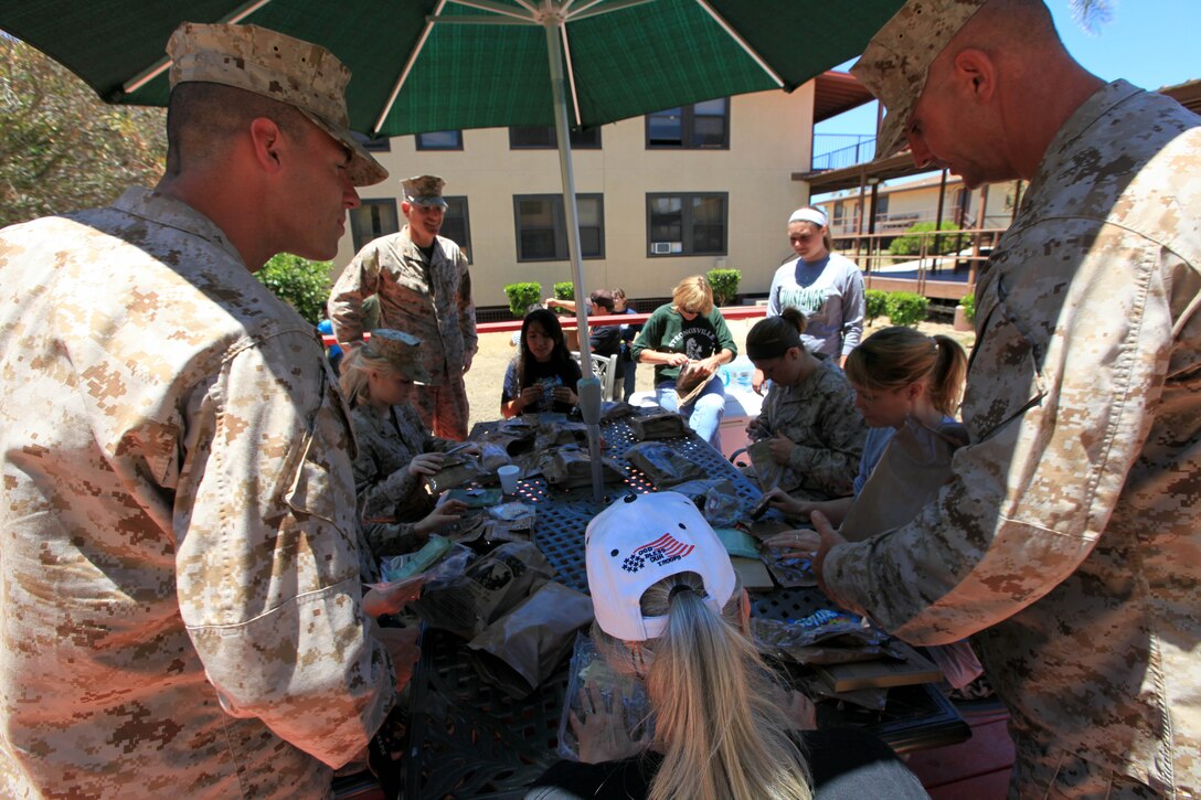 The Marines teach the spouses about Meals, Ready-to-Eat and how to prepare them for consumption during the Security Battalion's Jane Wayne Day on Camp Pendleton, June 23. After lunch, Col. Gino P. Amoroso and Sgt. Maj. Kenneth E. Warren presented each spouse with a certificate for participating in Jane Wayne Day. Amoroso is the commanding officer and Warren is the sergeant major of Security Bn.