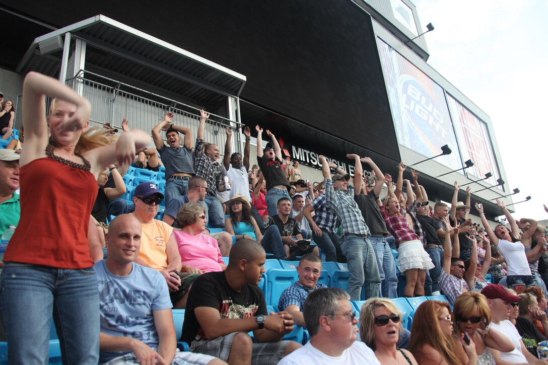 A group of Marines with the Single Marine Program of Cherry Point do the wave while they enjoy the live music of the 2012 Brothers of the Sun Tour at the Bank of America Stadium in Charlotte, N.C., June 24. The group loaded up two busses and made the trip to see the concert which featured Jake Owen, Grace Potter and the Nocturnals, Tim McGraw and Kenney Chesney.