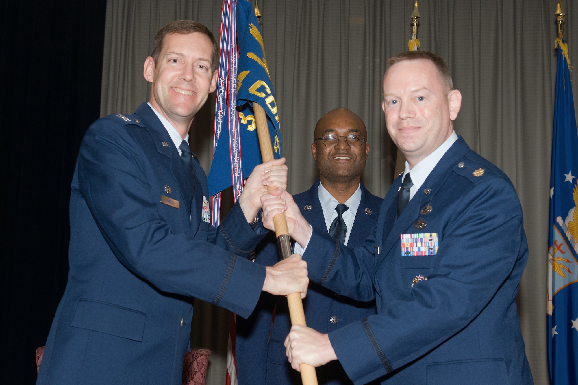 YOKOTA AIR BASE, Japan -- Col. Todd Freece, 374th Mission Support Group commander, left, passes the guidon to Maj. Christopher Wood, incoming 374th Contracting Squadron commander, during the 374th CONS change of command ceremony at Yokota Air Base, Japan, on June 22, 2012. Wood was the Chief, Workforce Management Branch, Force Development Division, Deputy Assistant Secretary (Contacting), Assistant Secretary of the Air Force (Acquisition), Washington, D.C. (U.S. Air Force photo by Osakabe Yasuo)