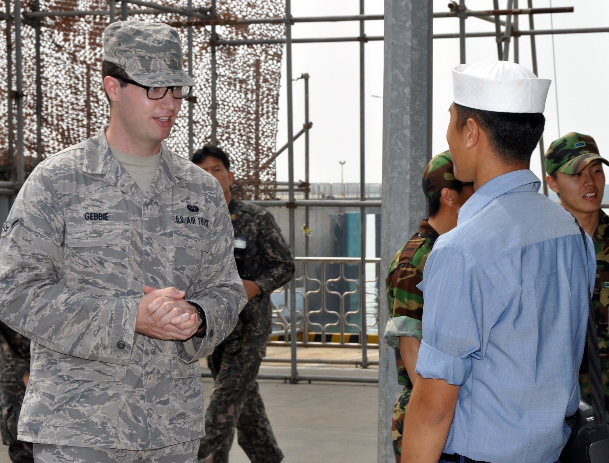 Airman Thomas Gebbie, 607th Support Squadron communications apprentice, speaks with a Republic of Korea Navy seaman during a tour of the ROK naval ship Cheonan at Pyeongtaek Navy Station, June 21, 2012. Approximately 30 U.S and ROK service members were given a free tour hosted by the ROK Air Force Operation Command to acknowledge Korean Security situations. Forty-six Korean service members were killed after an attack by a North Korean submarine March 26, 2010. (U.S. Air Force photo/Senior Airman Michael Battles) 