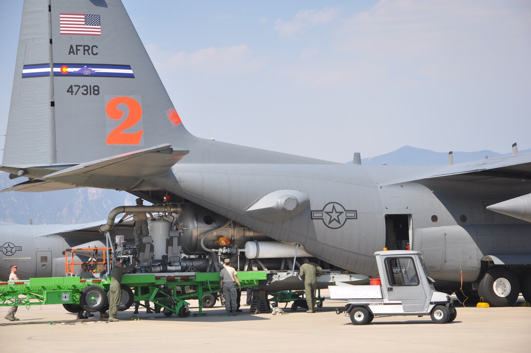 PETERSON AIR FORCE BASE, Colo. -- Air Force Reservists assigned to the 302nd Airlift Wing load a U.S. Forest Service Modular Airborne Fire Fighting System unit onto a C-130 Hercules here during the early morning hours June 24. The 302nd Airlift Wing has been tasked by the National Interagency Fire Center to support wildland aerial firefighting missions in the Rocky Mountain area. (U.S. Air Force photo//Ann Skarban)