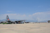 PETERSON AIR FORCE BASE, Colo. -- Air Force Reservists assigned to the 302nd Airlift Wing load a U.S. Forest Service Modular Airborne Firefighting System unit on C-130 Hercules June 24 during the early morning hours. Smoke from the Waldo Canyon fire, a wildland fire that started the day before can be seen near the Front Range off to the distance. The 302nd Airlift Wing has been tasked by the National Interagency Fire Center to support wildland firefighting missions in the Rocky Mountain area. (U.S. Air Force photo//Ann Skarban)