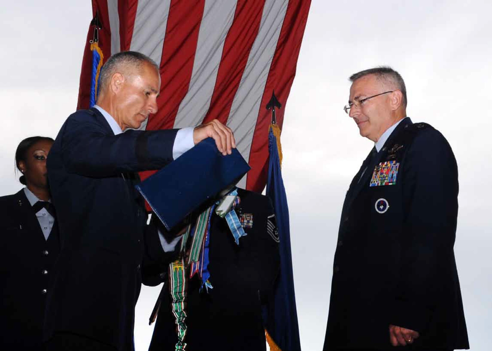 Brig. Gen. Karl McGregor, commander of the 452nd Air Mobility Wing, March Air Reserve Base, Calif., unsheathes a new 730th Air Mobility Training Squadron flag during the squadron re-activation and assumption of command, while Lt. Col. Jonathan M. Philebaum, 730th AMTS commander, Altus AFB, Okla., waits to assume command of the squadron at hangar 517 June 13, 2012. The 730th AMTS falls under the 452nd Air Mobility Wing at March ARB and is part of the Air Force Reserve Command. (U.S. Air Force photo by Airman 1st Class Franklin R. Ramos, 97th Air Mobility Wing)