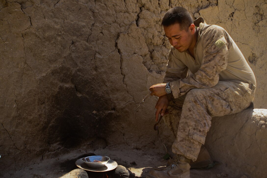 Petty Officer 3rd Class, Norberto Zamora, a hospital corpsman with 2nd Battalion, 5th Marines, Regimental Combat Team 6, cooks luncheon meat, July 5, 2012. Corpsmen in the field need to bring a wide variety of medical tools and supplies to be prepared for any injury that may occur.