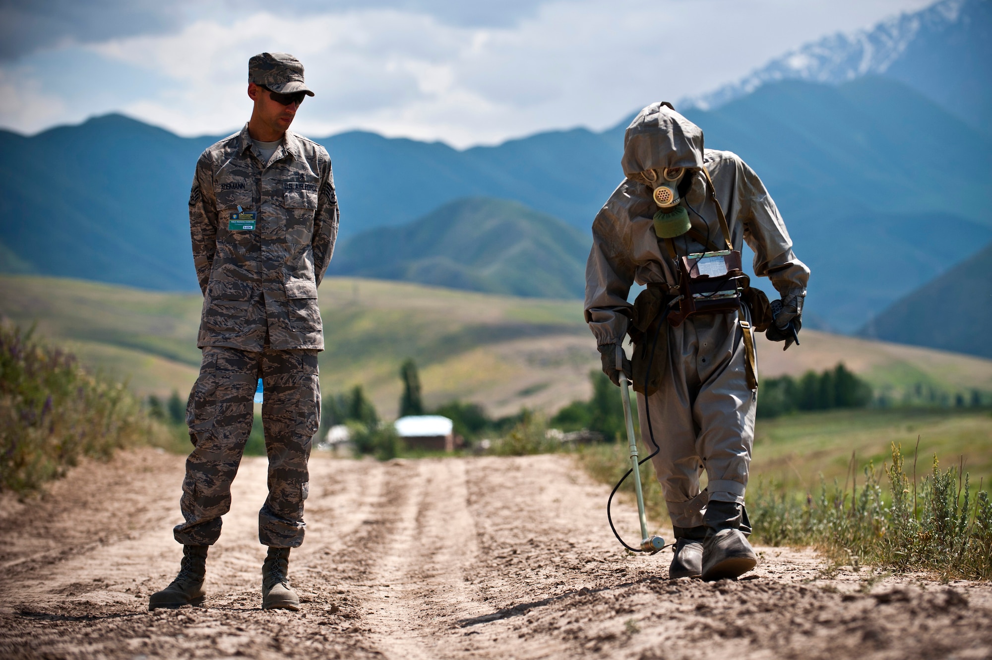 Staff Sgt. Eduardo Ausmann observes Kyrgyz Republic Lt. Salamat Temirbekov search for simulated contaminated materials as part a chemical, biological, radiological, nuclear, and explosives training scenario during Exercise Regional Cooperation 12 at the Koi Tash Military Academy, June 22, 2012. Service members from the Transit Center at Manas participated in the exercise to help strengthen relationships and cooperation of attending nations. Regional Cooperation 12 is a multinational exercise designed to strengthen relationships and promote regional cooperation among the participating nations while offering coordinated, rapid response scenarios in the event of a disaster affecting multiple countries within the region. Ausmann is a 376th Expeditionary Medical Group bioenvironmental engineer deployed out of Wright Patterson Air Force Base, Ohio and is a native of Porto Alegre, Brazil. (U.S. Air Force photo/Senior Airman Brett Clashman)