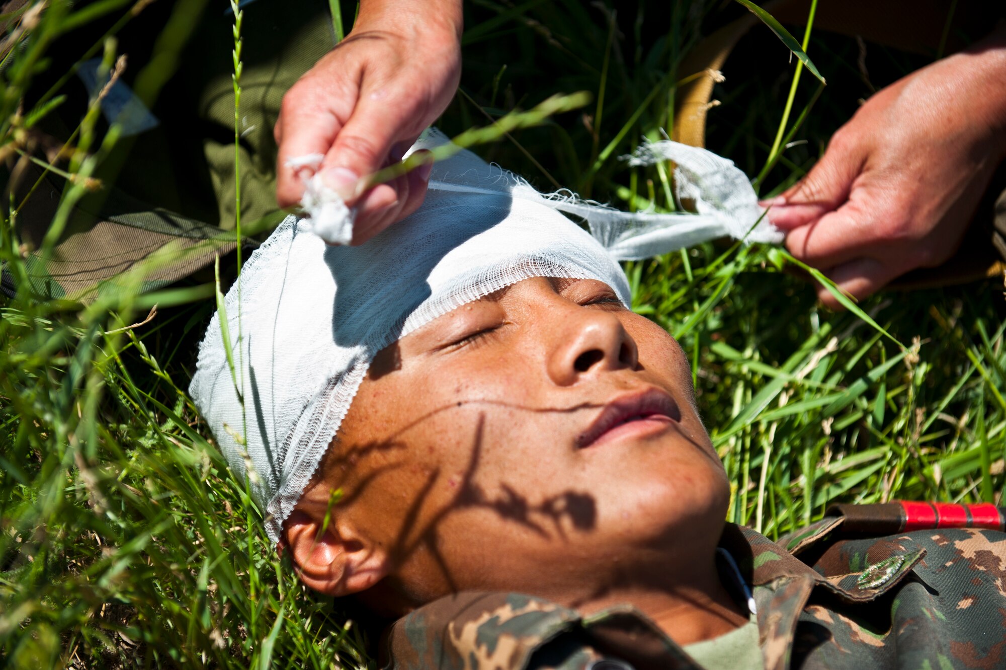 A Kyrgyz Republic soldier bandages a simulated casualty's forehead in a mass casualty scenario during Exercise Regional Cooperation 12 at the Koi Tash Military Academy, Kyrgyzstan, June 22, 2012. The training scenario tested first responders on reaction time, aid requirements and rate of evacuation. Regional Cooperation 12 is a multinational exercise designed to strengthen relationships and promote regional cooperation among the participating nations while offering coordinated, rapid response scenarios in the event of a disaster affecting multiple countries within the region. (U.S. Air Force photo/Senior Airman Brett Clashman)