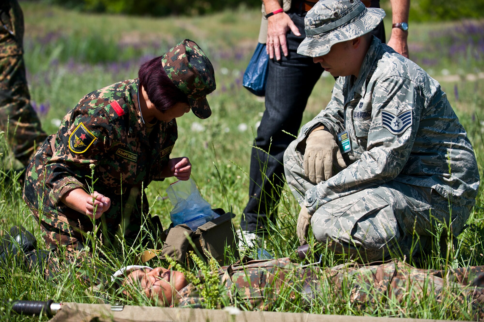 Staff Sgt. Adam Auzchek observes how Kyrgyz Republic Master Sgt. Ina Belikovah treats a simulated casualty during a mass casualty scenario as part of Exercise Regional Cooperation 12, at the Koi Tash Military Academy, Kyrgyzstan, June 22, 2012. The U.S. and Kyrgyz Republic, along with partner nations Afghanistan, Tajikistan and Kazakhstan, worked to strengthen their partnership through cooperation and mutual capabilities in the exercise. Regional Cooperation 12 is a multinational exercise designed to strengthen relationships and promote regional cooperation among the participating nations while offering coordinated, rapid response scenarios in the event of a disaster affecting multiple countries within the region. Auzchek is a 376th Expeditionary Civil Engineer Squadron emergency management journeyman deployed out of Fairchild Air Force Base, Wash. and is a native of Denver. (U.S. Air Force photo/Senior Airman Brett Clashman)
