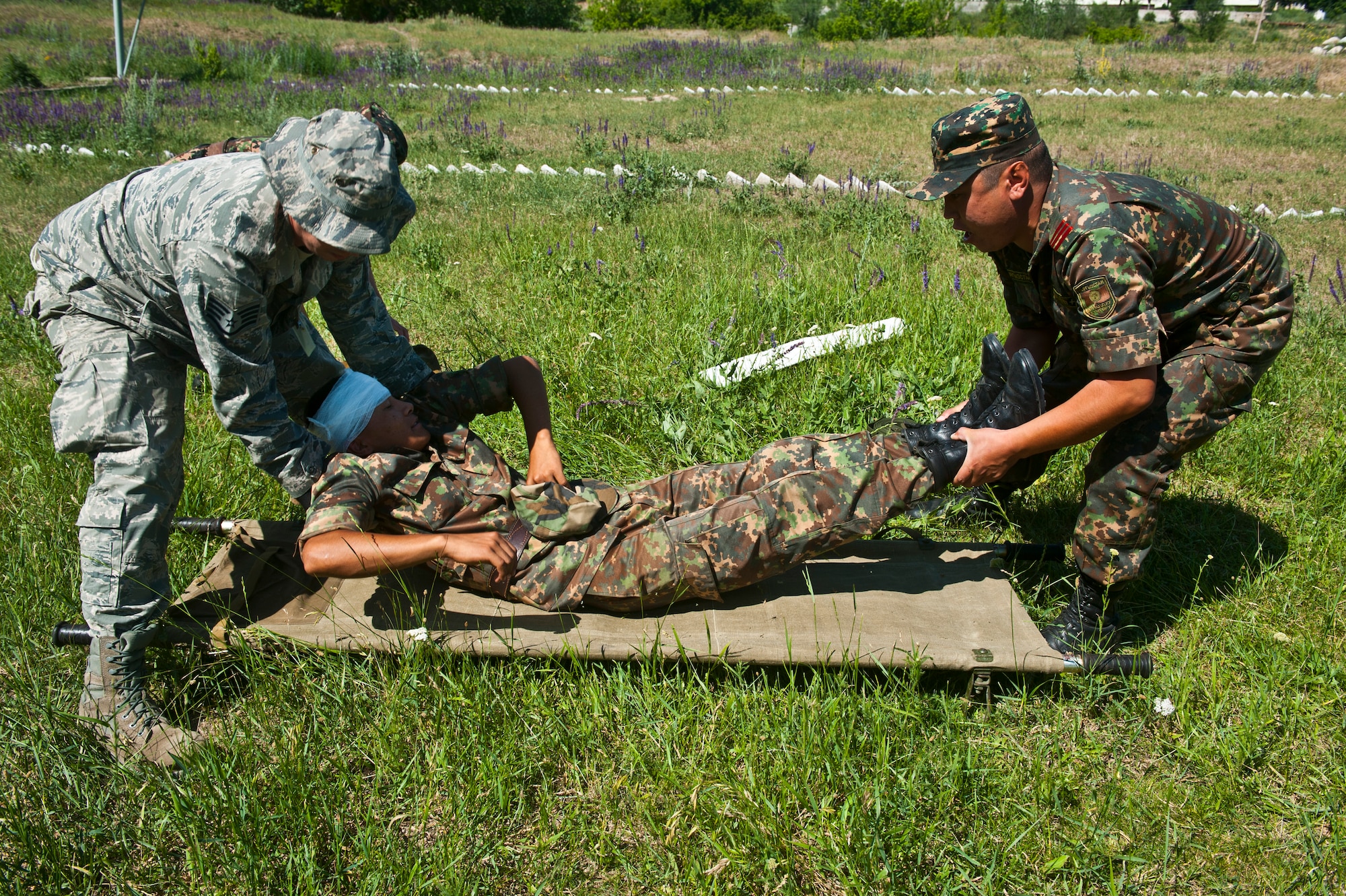 Staff Sgt. Adam Auzchek and Kyrgyz Republic Sgt. Nuvalik Bekovah move a simulated casualty on to a litter during a mass casualty scenario as part of Exercise Regional Cooperation 12, at the Koi Tash Military Academy, Kyrgyzstan, June 22, 2012. The U.S. and Kyrgyz Republic, along with partner nations Afghanistan, Tajikistan and Kazakhstan worked to strengthen their partnership through this cooperation and mutual capabilities in the exercise. Regional Cooperation 12 is a multinational exercise designed to strengthen relationships and promote regional cooperation among the participating nations while offering coordinated, rapid response scenarios in the event of a disaster affecting multiple countries within the region. Auzchek is a 376th Expeditionary Civil Engineer Squadron emergency management journeyman deployed out of Fairchild Air Force Base, Wash. and is a native of Denver. (U.S. Air Force photo/Senior Airman Brett Clashman)