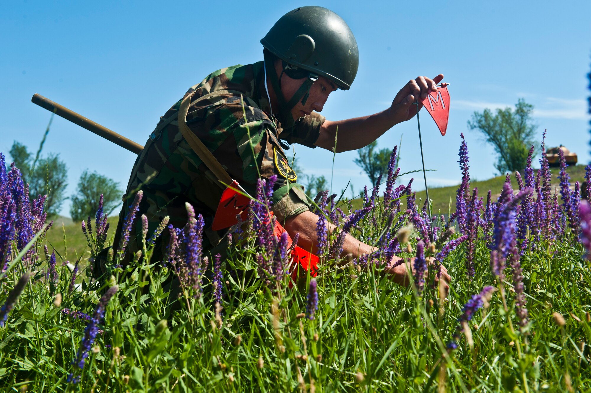 Kyrgyz Republic Cpl. Azamat Kemirkov places a landmine marker in the ground during Exercise Regional Cooperation 12 at the Koi Tash Military Academy, Kyrgyzstan, June 22, 2012. Regional Cooperation 12 is a multinational exercise designed to strengthen relationships and promote regional cooperation among the participating nations while offering coordinated, rapid response scenarios in the event of a disaster affecting multiple countries within the region. (U.S. Air Force photo/Senior Airman Brett Clashman)