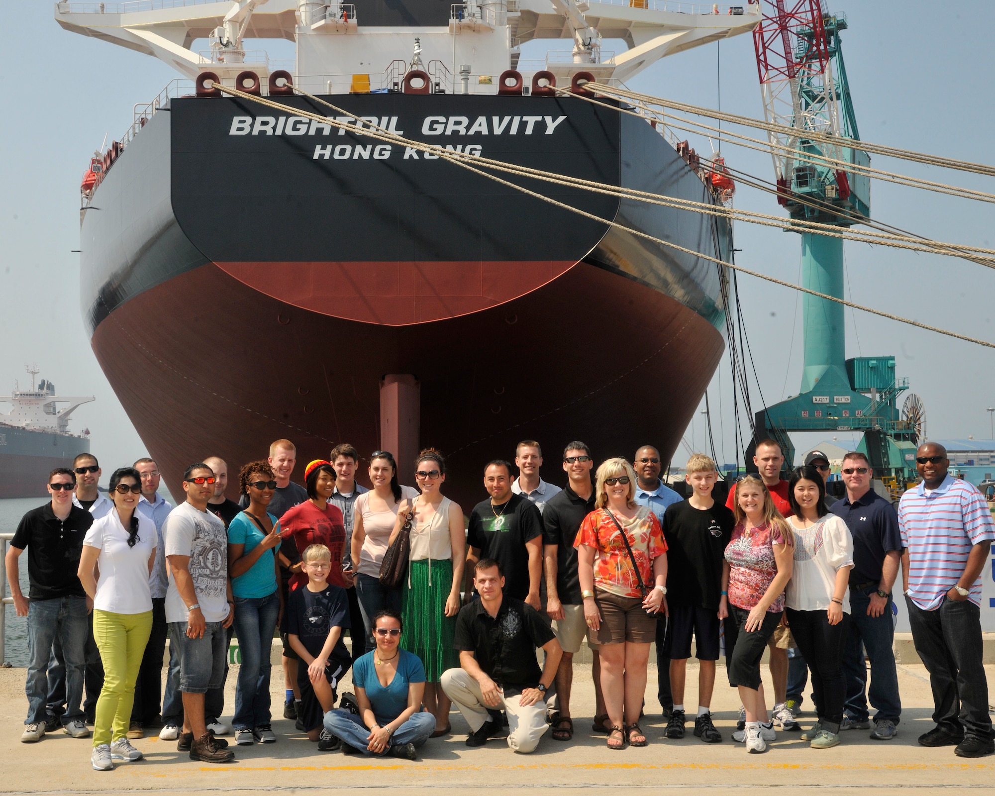 Members of the 8th Fighter Wing Gunsan City Cultural Tour pose for a picture at a South Korea shipyard near the Saemangeum Seawall in Gunsan, Republic of Korea, June 20, 2012. The shipyard just recently constructed a new building for constructing vessels similar to the oil ship in the picture. (U.S. Air Force photo/ Senior Airman Marcus Morris)