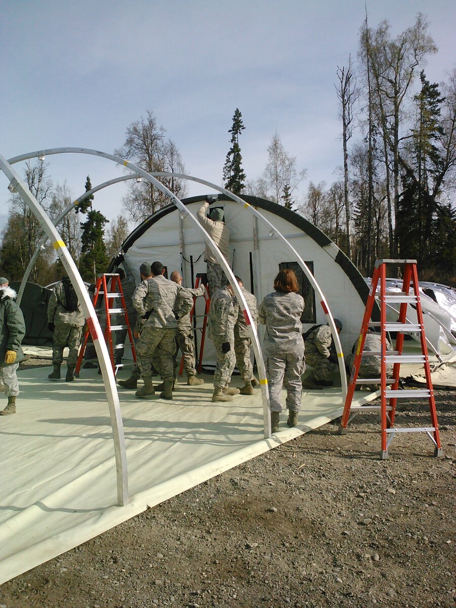 Airmen from the Pacific Theater build an "Emergency Medical Support +10" field hospital at Camp Mad Bull at Joint Base Elmendorf-Richardson May 8.  The EMEDS +10 package is a novel Pacific Air Forces concept that includes a field hospital and a contingency response group in response to humanitarian and disasterrelief operations. (U.S. Air Force photo by 1st Lt. Kathleen Eisenbrey)