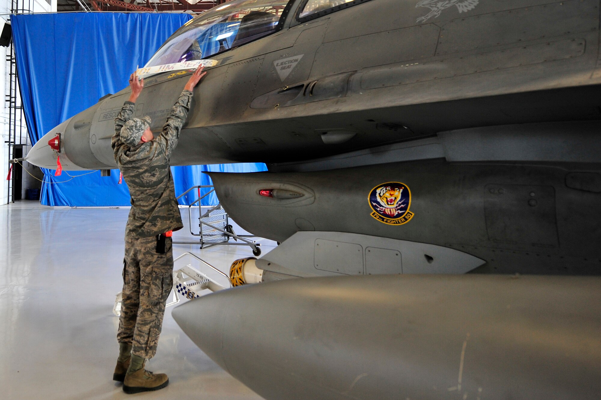 U.S. Air Force Airman 1st Class Nathanael Burgess, 20th Aircraft Maintenance Squadron crew chief, unveils Col. Shaun McGrath’s name, displayed on the side of an F-16 Fighting Falcon, June 22, 2012, Shaw Air Force Base, S.C. The F-16 is McGrath’s assigned aircraft after taking over as the 20th Operations Group commander.  (U.S. Air Force photo by Senior Airman Kenny Holston/Released)