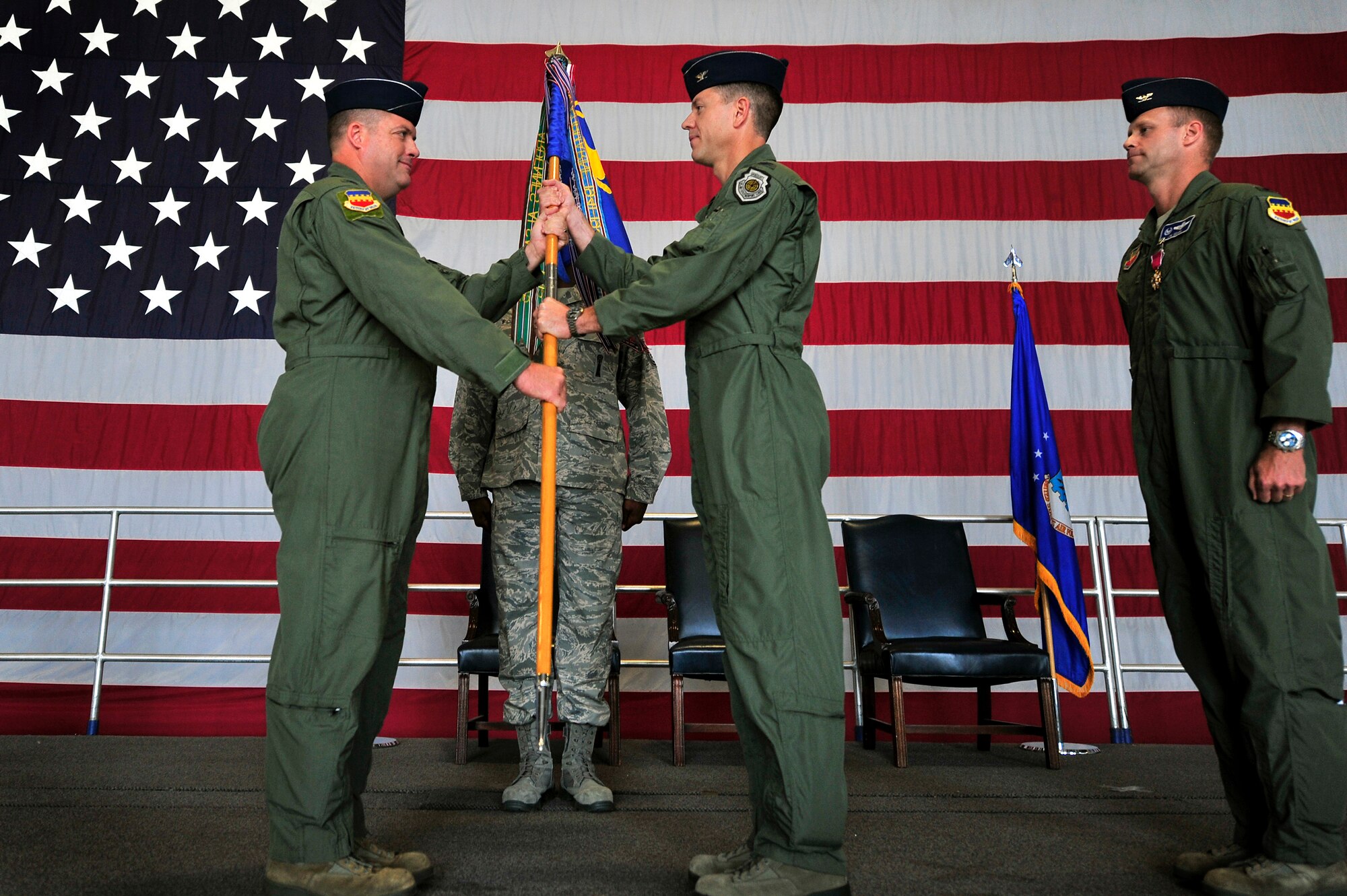 U.S. Air Force Col. Don Godier, 20th Fighter Wing vice commander, (left) passes the 20th Operations Group unit flag to Col. Shaun McGrath as he takes command of the 20th OG during a change of command ceremony, June 22, 2012, Shaw Air Force Base, S.C. Col. James Sears, outgoing 20th OG commander, will be taking a new assignment at Columbus Air Force Base, Miss. while McGrath has taken over as the new 20th OG commander. (U.S. Air Force photo by Senior Airman Kenny Holston/Released) 