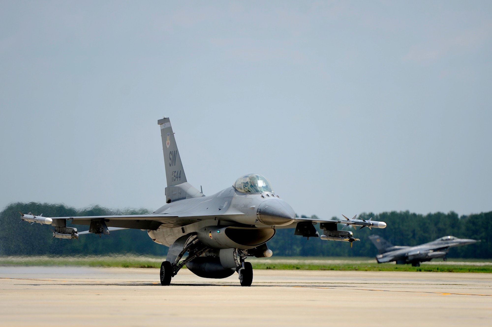 A U.S. Air Force F-16 Fighting Falcon taxis back to its parking spot as other F-16s take off to perform sorties, June 19, 2012, Shaw Air Force Base, S.C. Flight operations at Shaw AFB are constant as pilots must keep their skills sharp to meet the demands of any global mission at a moment’s notice. (U.S. Air Force photo by Senior Airman Kenny Holston/Released)