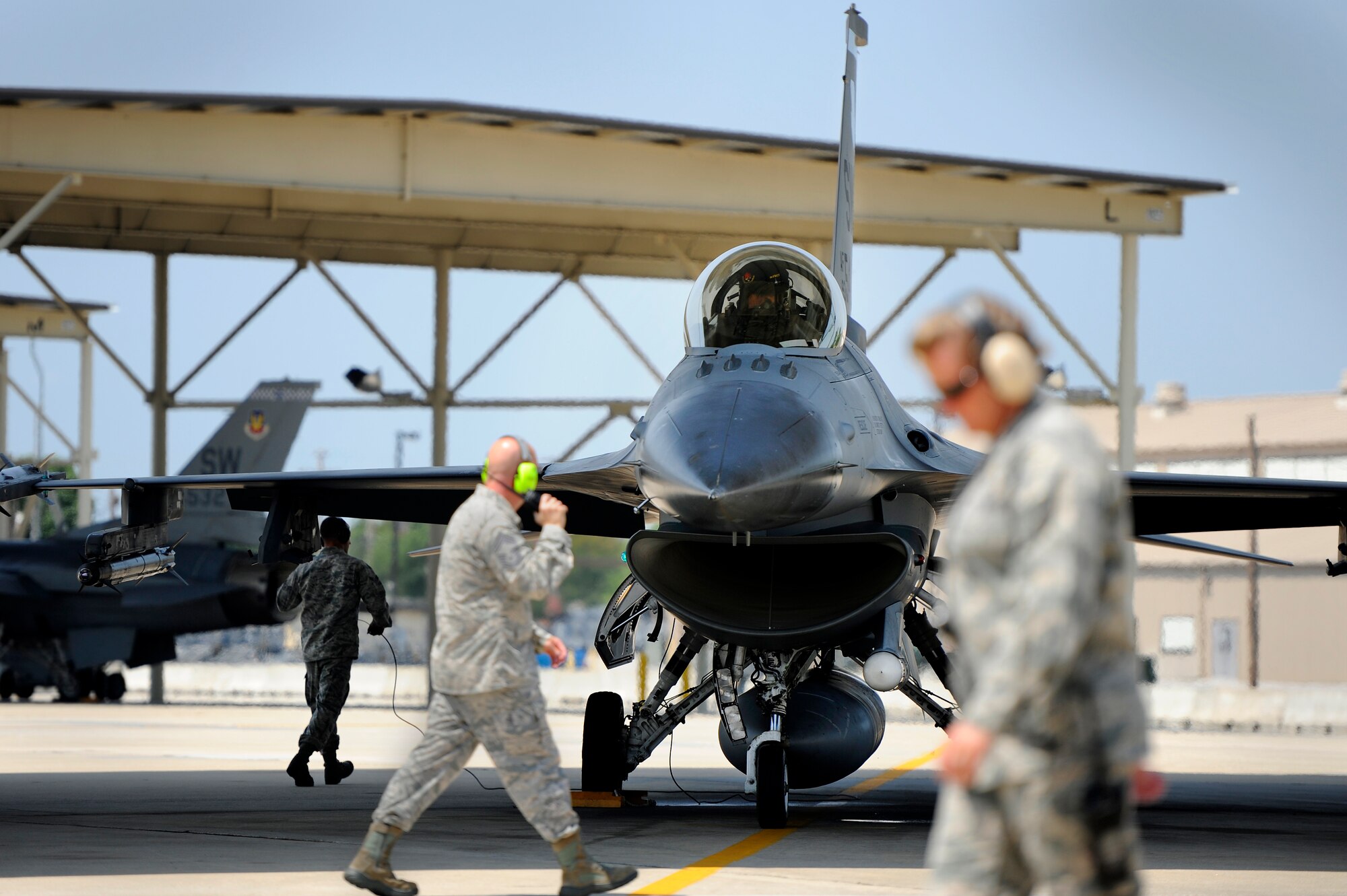 Flight line personnel at Shaw Air Force Base, S.C. stay on the move as F-16 Fighting Falcons are prepped and launched, June 19, 2012. U.S. Air Force fighter pilots assigned to one of the three fighter squadrons under the 20th Fighter Wing perform sorties on a daily basis to stay proficient and mission ready to meet the demands of any worldwide tasking at a moment’s notice. (U.S. Air Force photo by Senior Airman Kenny Holston/Released)