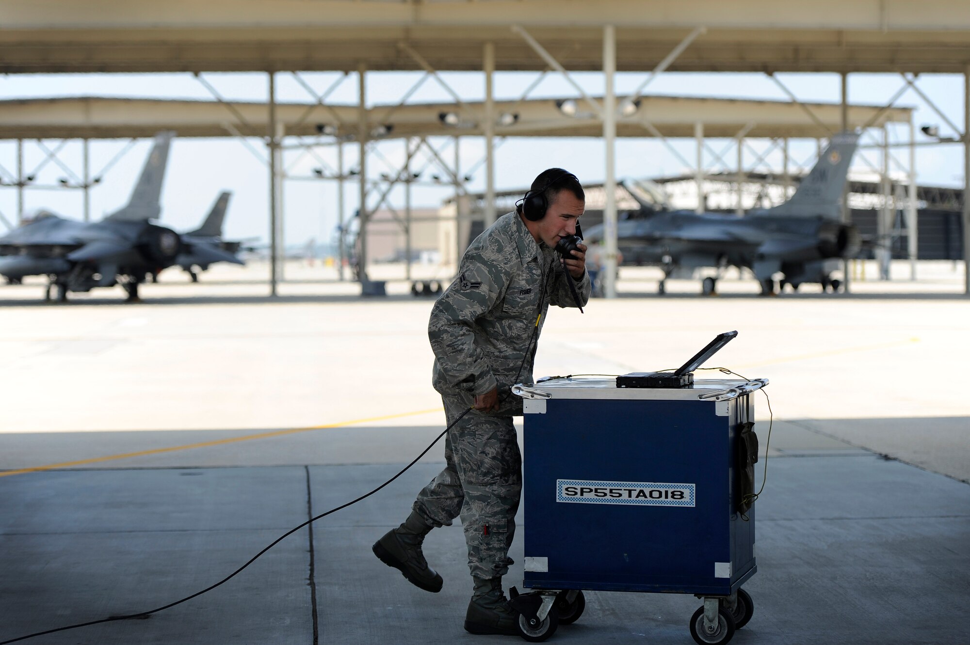 U.S. Air Force Airman 1st Class Brian Fisher, 20th Aircraft Maintenance Squadron crew chief, communicates with the pilot of an F-16 Fighting Falcon as he refers to his technical order manual while prepping to launch the F-16, June 19, 2012, Shaw Air Force Base, S.C. Crew chiefs assigned to the 20th AMXS work around the clock maintaining and launching F-16’s for three fighter squadrons assigned to the 20th Fighter Wing. (U.S. Air Force photo by Senior Airman Kenny Holston/Released)