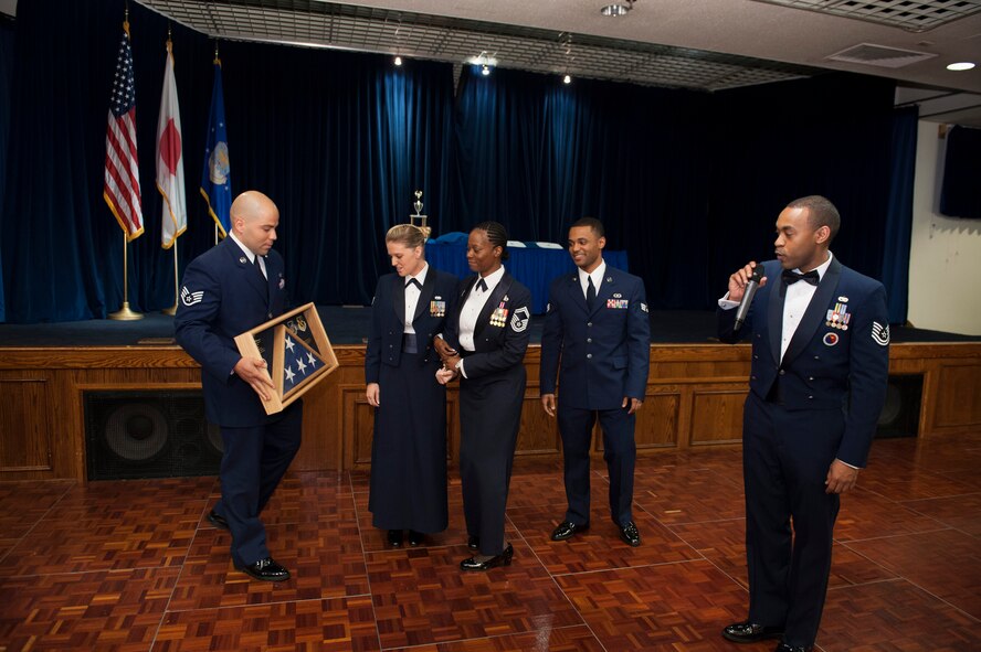 YOKOTA AIR BASE, Japan -- Previous John L. Levitow Award winners and Airman Leadership School staff present Senior Master Sgt. Nanette Klingaman, center, ALS commandant, with a shadow box as a farewell gift during an ALS graduation for class 12-E June 21, 2012, at Yokota Air Base, Japan. The flag was flown outside the Professional Military Education Center for the entire three years Klingaman was commandant. (U.S. Air Force photo by Tech. Sgt. Samuel Morse)