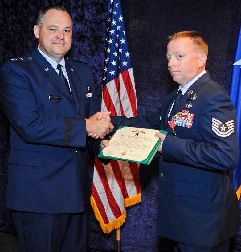 Maj. Gen. Jim Butterworth, Georgia National Guard adjutant general, presents a certificate to accompany the Bronze Star Medal to Tech. Sgt. Barry Duffield, 116th Civil Engineering Squadron explosive ordnance technician, during a ceremony at the Museum of Aviation, Robins Air Force Base, Ga., June 18, 2012.  Duffield received the medal, his 2nd, for his achievements while serving as an explosive ordnance disposal team leader in Afghanistan during a six-month period from 2011 to 2012.  
(National Guard photo by Master Sgt. Roger Parsons/Released)
