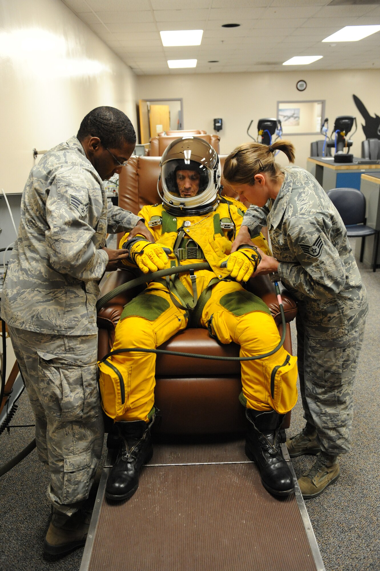 (Left) Senior Airman Michael Gaines and (right) Staff Sgt. Tara Schmidt, , 9th Physiological Support Squadron life support technicians, dress Chief Masters Sgt. Richard Parsons, command chief of Air Combat Command, in a U-2 Dragon Lady pressure suit at the 9th PSPTS integration room June 21, 2012 at Beale Air Force Base, Calif.  Parsons was visiting base facilities and meeting Airmen from units and organizations responsible for accomplishing the mission of the 9th Reconnaissance Wing and tenant units. (U.S. Air Force photo by Mr. John Schwab)