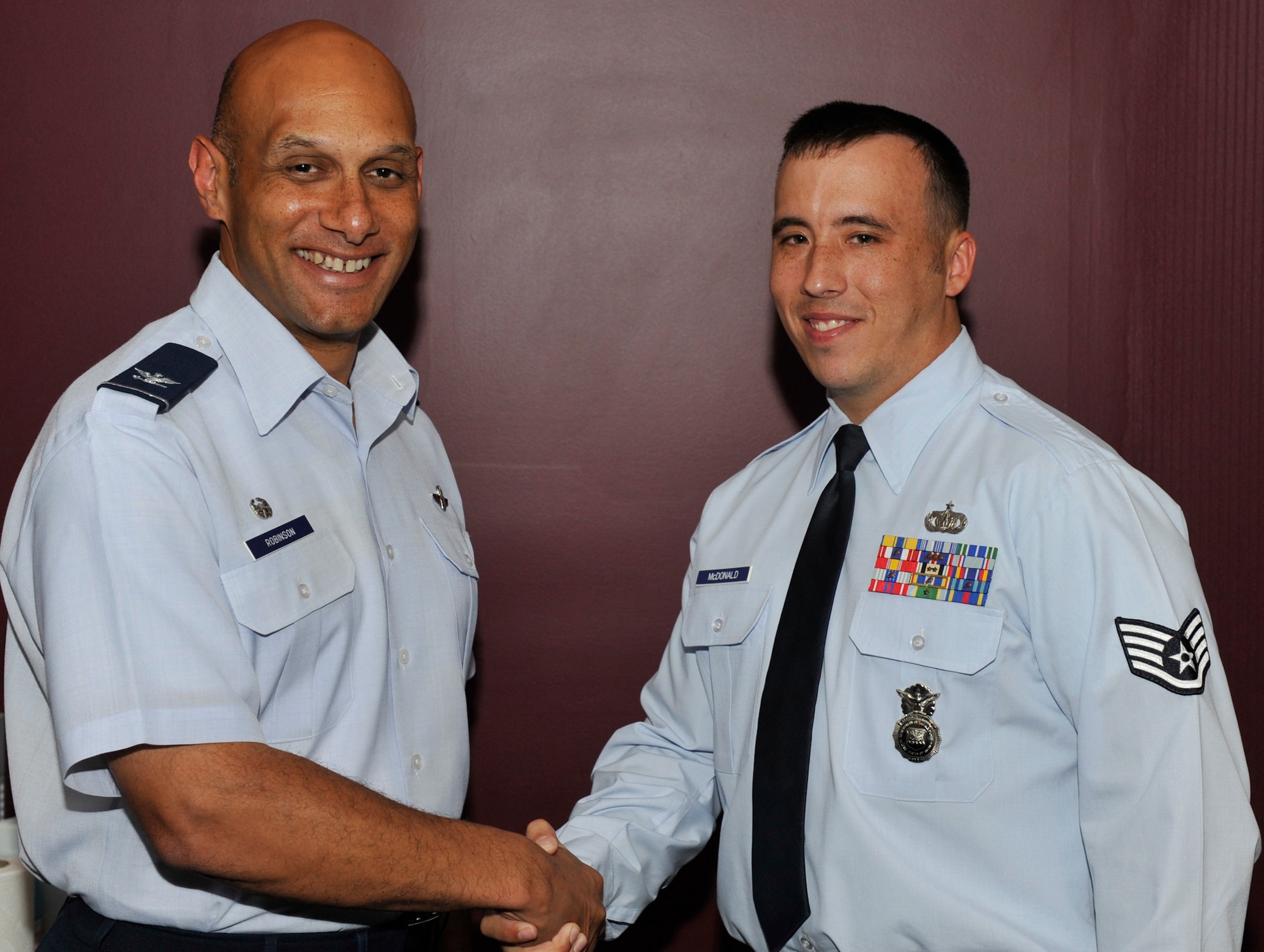 Col. Brian Robinson, 19th Airlift Wing commander congratulates Staff Sgt. Justin McDonald, a 19th Security Forces Squadron non-commissioned officer in charge of pass and registration, for his selection as the Combat Airlifter of the Week June 25, 2012, at Little Rock Air Force Base, Ark. McDonald, a Walterboro, S.C. native, moved the form for a restricted area badge from paper to digital which cut the time to get a badge in half.  (U.S. Air Force photo/A1C Rusty Frank)
