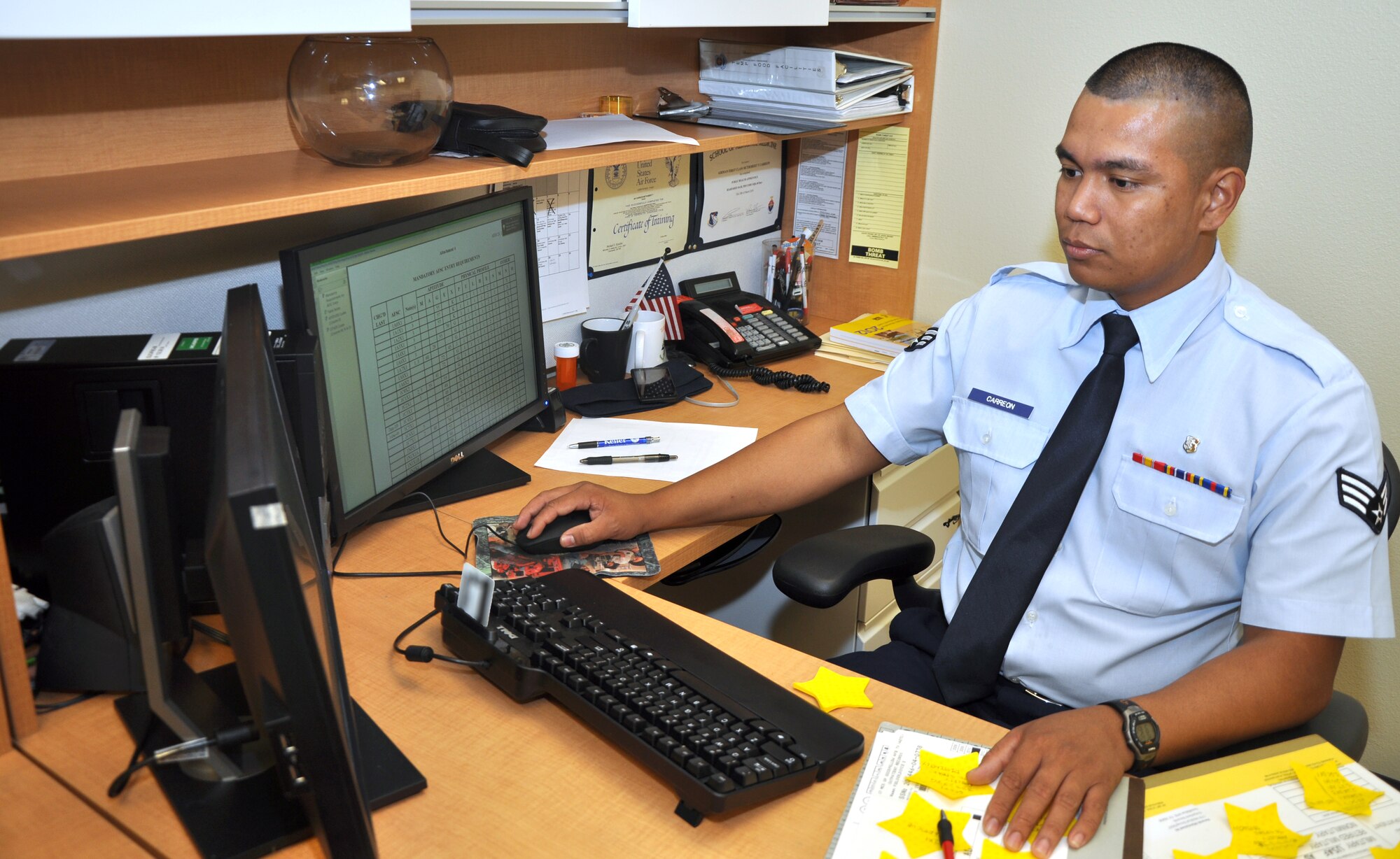 GOODFELLOW AIR FORCE BASE, Texas-- Senior Airman Senior Airman McThobert Carreon, 17th Medical Operations Squadron public health technician, works at his desk in the Ross Clinic June 25. Carreon is an immigrant from the Philippines and his first time in the U.S. was on his way to basic training. (U.S. Air Force photo/Airman 1st Class Jessica Keith) 