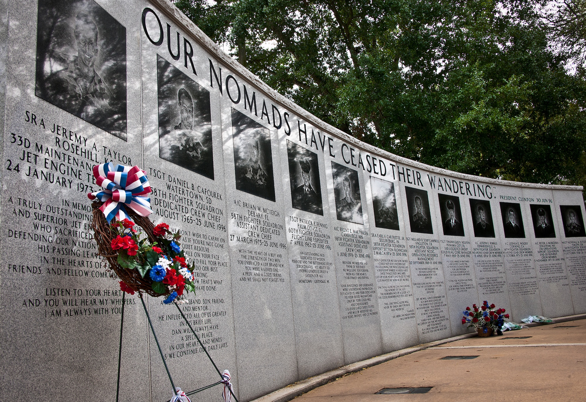 Flowers and wreaths were placed along the Khobar Towers Memorial Wall to honor the fallen on the 16th anniversary of the tragic bombing that killed 19 military members and 12 33rd Fighter Wing Nomads.  (U.S. Air Force photo/Samuel King Jr.)