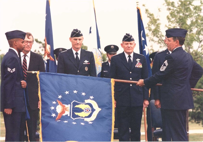 Secretary of the Air Force Dr. Donald B. Rice (from center left), Air Force Chief of Staff Gen. Merrill A. McPeak and Air Force Materiel Command Commander Gen. Ronald W. Yates stand as the AFMC flag is unfurled at the command's activation ceremony July 1, 1992. This year AFMC celebrates its 20th anniversary of providing expeditionary capabilities to the warfighter through development and transition of technology, acquisition management, test and evaluation, and sustainment of all Air Force weapon systems.  (File photo)