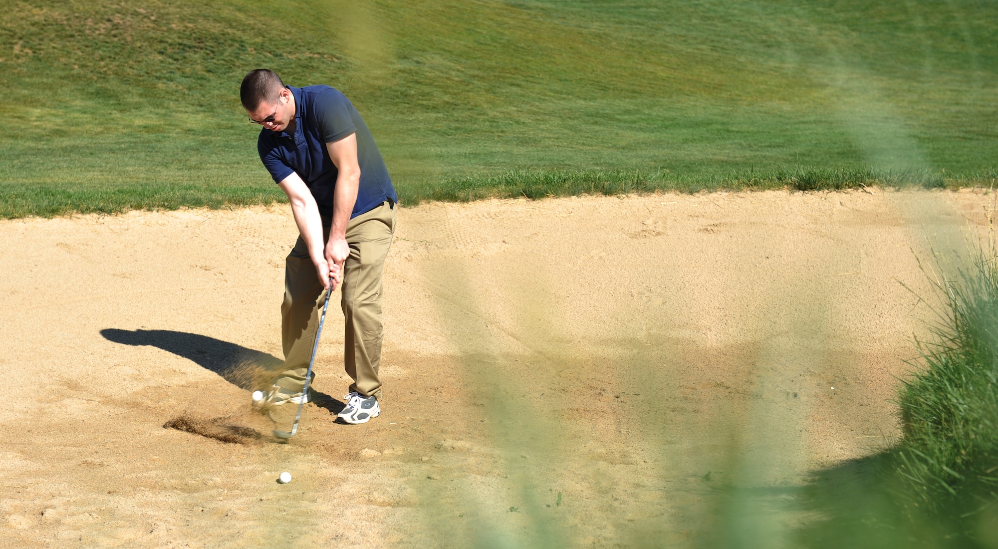 AURORA, Colo. — Staff Sgt. Nicholas Rau, 460th Space Wing Public Affairs journalist, chips out of the bunker at Murphy Creeks Golf Course June 19, 2012.  The golf course offers one of the better practice facilities in all of the state, according to Chris Manning, a golf-shop associate at the course.  The golf course was designed by Ken Kavanaugh and opened to the public in 1999. (U.S. Air Force photo by Airman 1st Class Darryl Bolden Jr.)