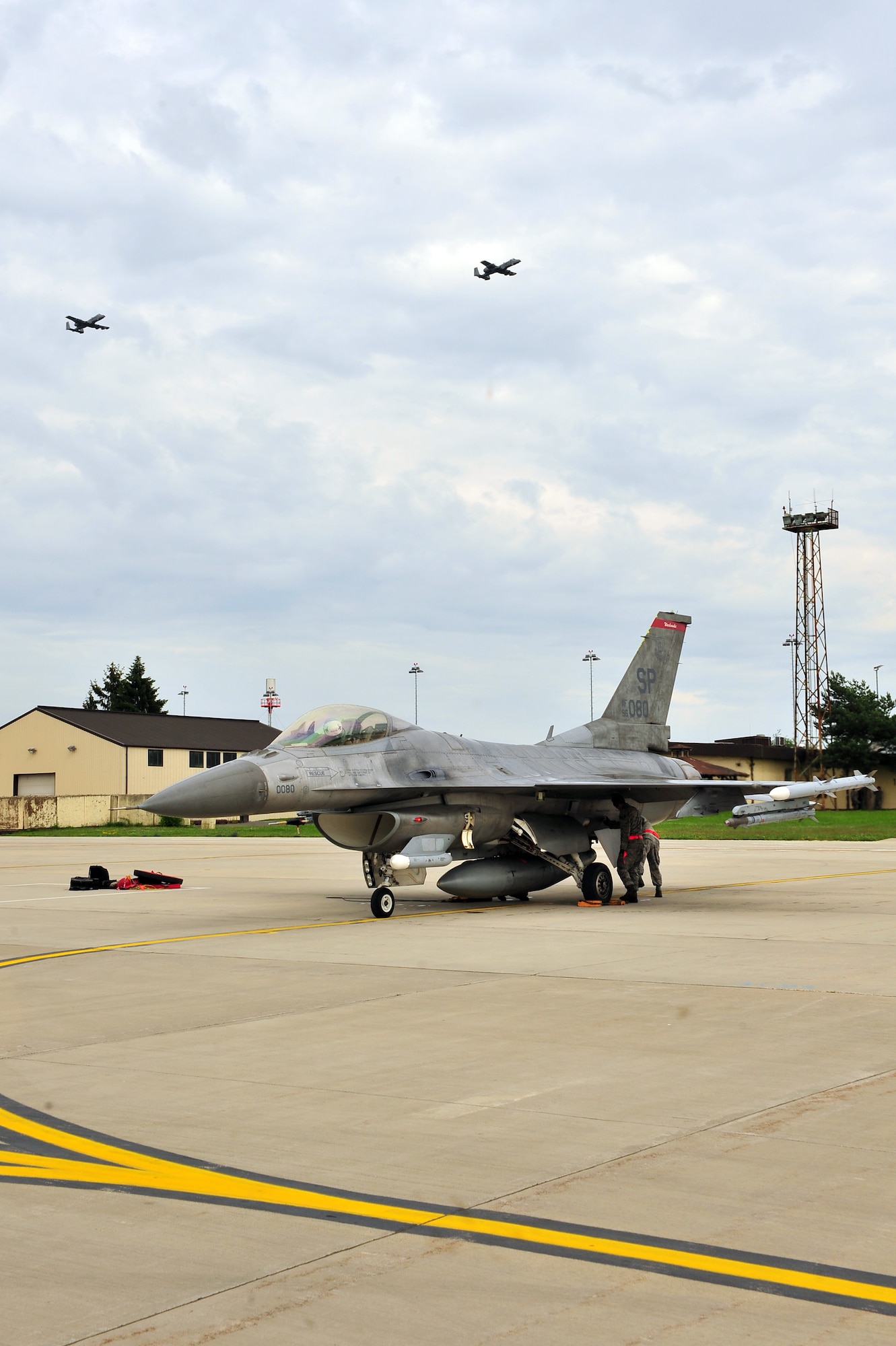 SPANGDAHLEM AIR BASE, Germany – Brig. Gen. Chris Weggeman, 52nd Fighter Wing commander, parks an F-16 Fighting Falcon after his final flight here while two A-10 Thunderbolt II aircraft fly overhead June 21. Weggeman commanded the 52nd FW for two years. (U.S. Air Force photo by Airman 1st Class Dillon Davis/Released)