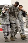 U.S. Air Force Capt. Amalia Solano, left, 35th Medical Group patient care team member, and Staff Sgt. Hyun Cho, right, 35 MDG aerospace medical technician, move simulated patient Airman 1st Class James Powell, 35th Security Forces Squadron member, during an emergency management exercise at Misawa Air Base, Japan, June 25, 2012. The exercise tested the bases’ ability to respond to a natural disaster. (U.S. Air Force photo by Staff Sgt. Nathan Lipscomb/Released)