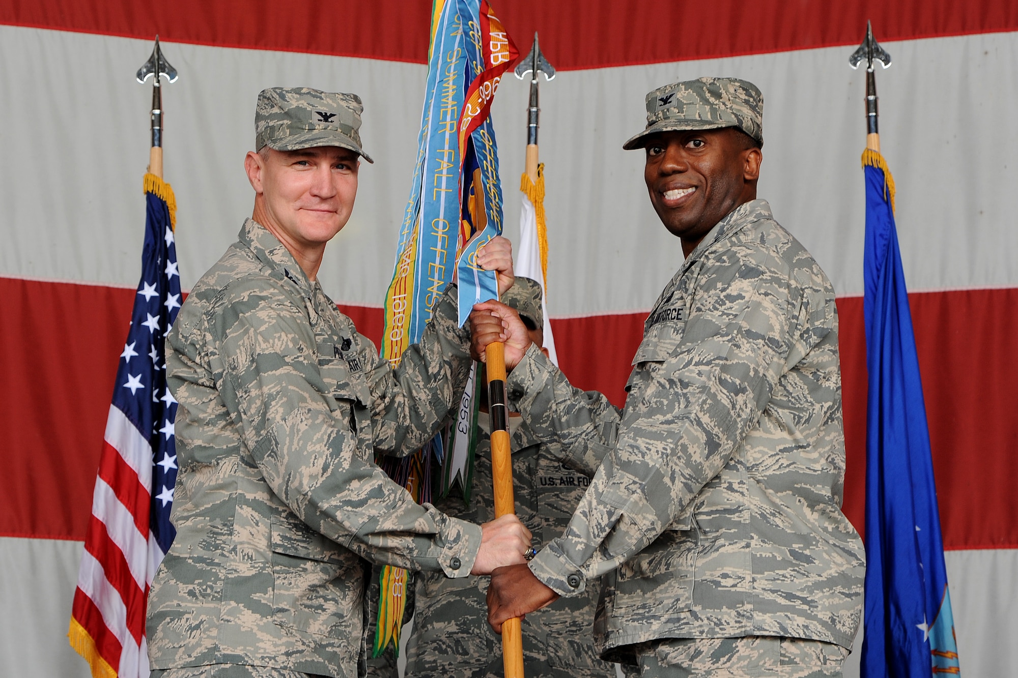 Col. John Pearse, 8th Fighter Wing commander, hands the 8th Mission Group guidon to Col. Joseph Atkins, 8th MSG commander, during a change of command ceremony at Kunsan Air Base, Republic of Korea, June 22, 2012. Atkins was last assigned to the Pentagon in Washington, D.C. (U.S. Air Force photo/Staff Sgt. Rasheen A. Douglas)