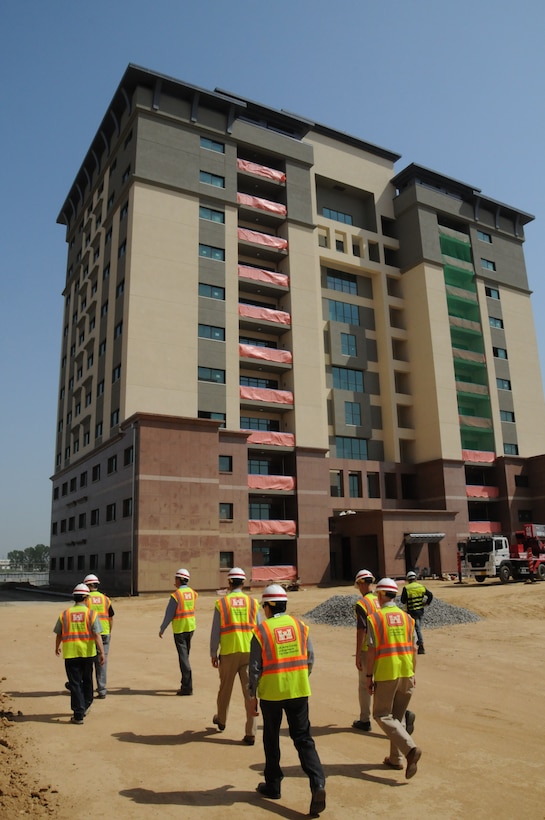 U.S. Army Corps of Engineers employees walk towards a family housing tower on U.S. Army Garrison Humphreys.
