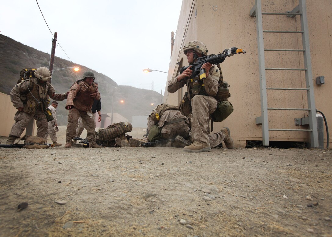 A corpsman with Field Medical Training Battalion West provides security to his fellow students as they administer first aid to role-playing victims of an improvised explosive device during a final training exercise at Camp Pendleton, Calif., June 21. 