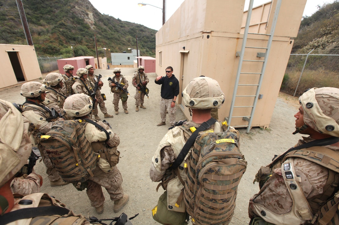 Petty Officer 2nd Class Kristofer Baskett, an instructor with Field Medical Training Battalion West, instructs a group of corpsmen during a final training exercise at Camp Pendleton, Calif., June 21. 