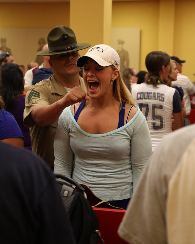 Julie Buehler shouts into an fake microphone during the intial receiption at Marine Corps Recruit Depot San Diego. The  sports talk radio host for KXPS-A (TEAM 1010)/Palm Springs midday "BUEHLER'S DAY OFF" arrived June 26 to participate in the week long Educators Workshop.  The workshop introduces visitors to the rigors of recruit training.