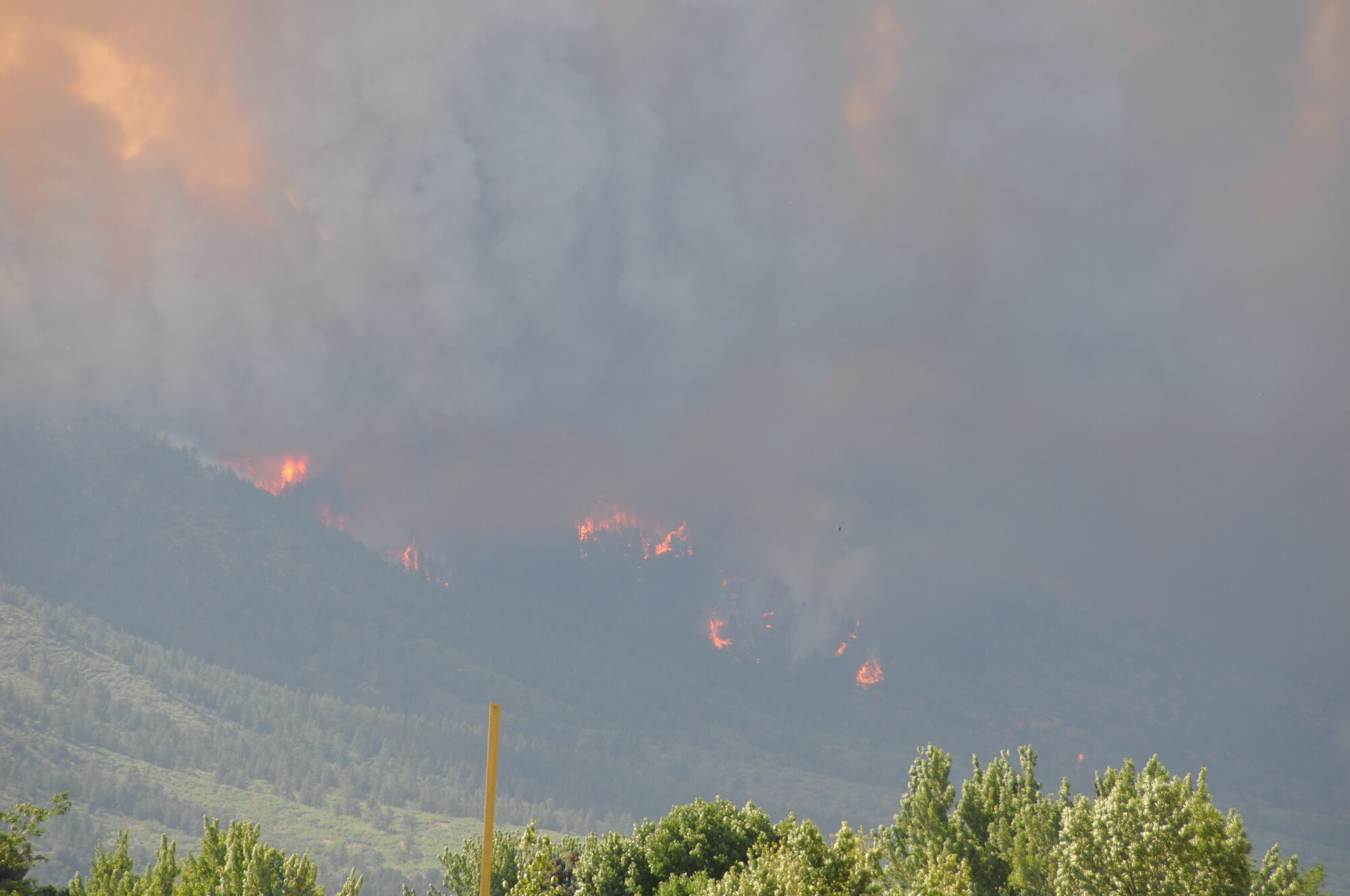 Smoke and flames from the Waldo Canyon fire can be seen at nearby Coronado High School in western Colorado Springs, Colo.  Worsening fire conditions prompted National Forest Service officials to re-evaluate the utilization of aerial resources. (U.S. Air Force photo/1st Lt. Rusty Ridley)
